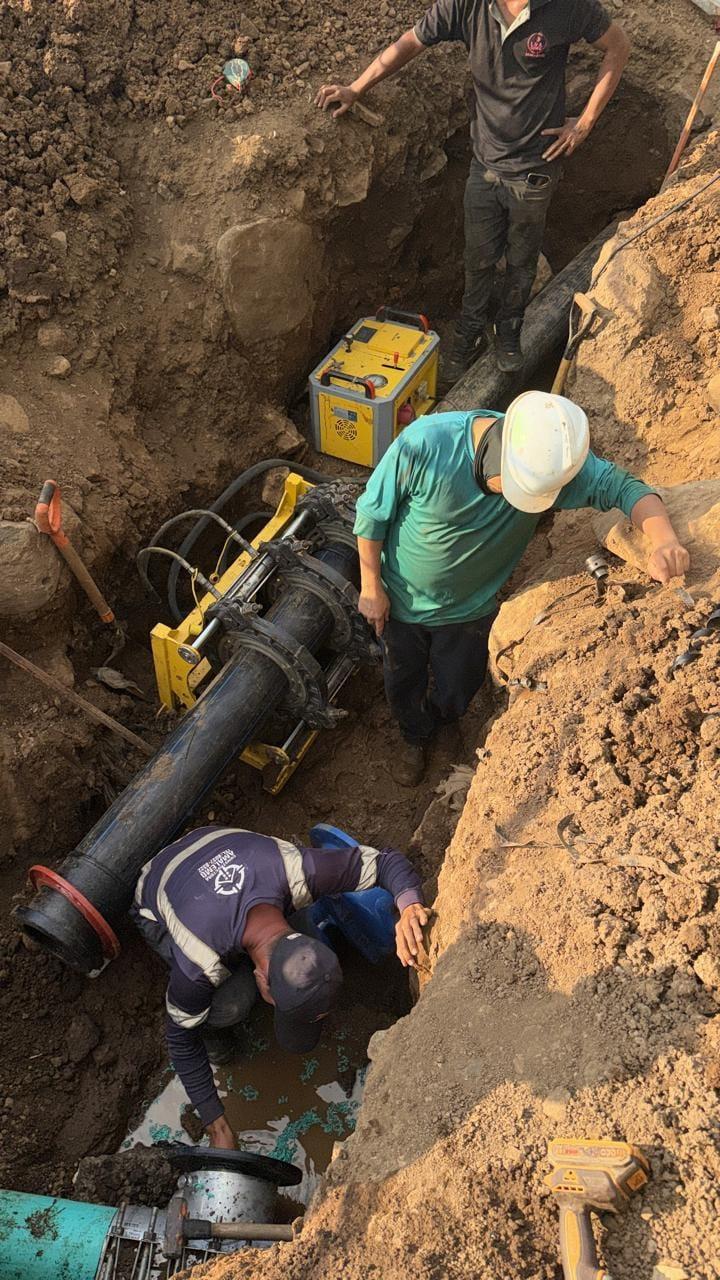 Técnicos uniendo tubería de agua potable con equipo de electrofusión dentro de una zanja